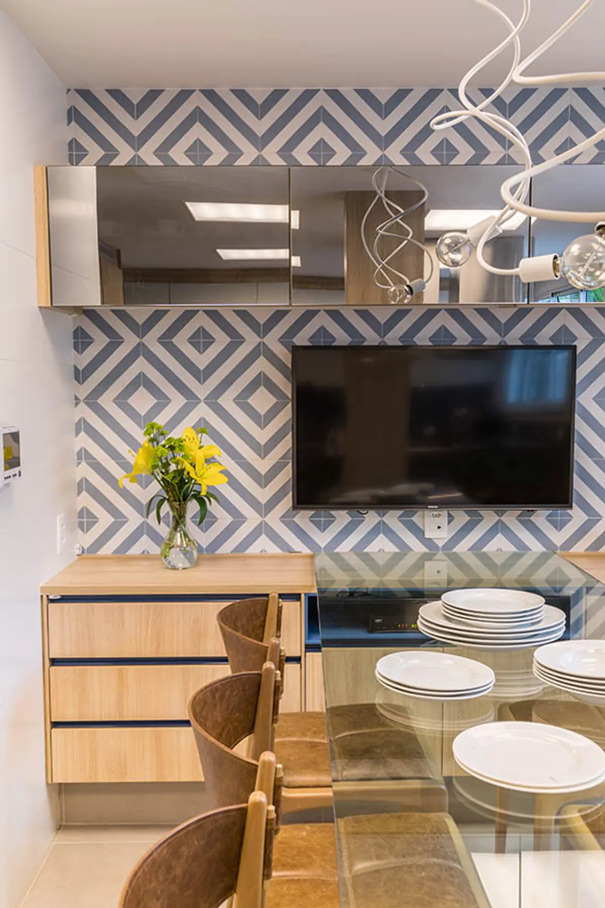 Comedor moderno con revestimiento geométrico azul y blanco, TV integrada — proyecto Casa Barra ED, por Amanda Miranda