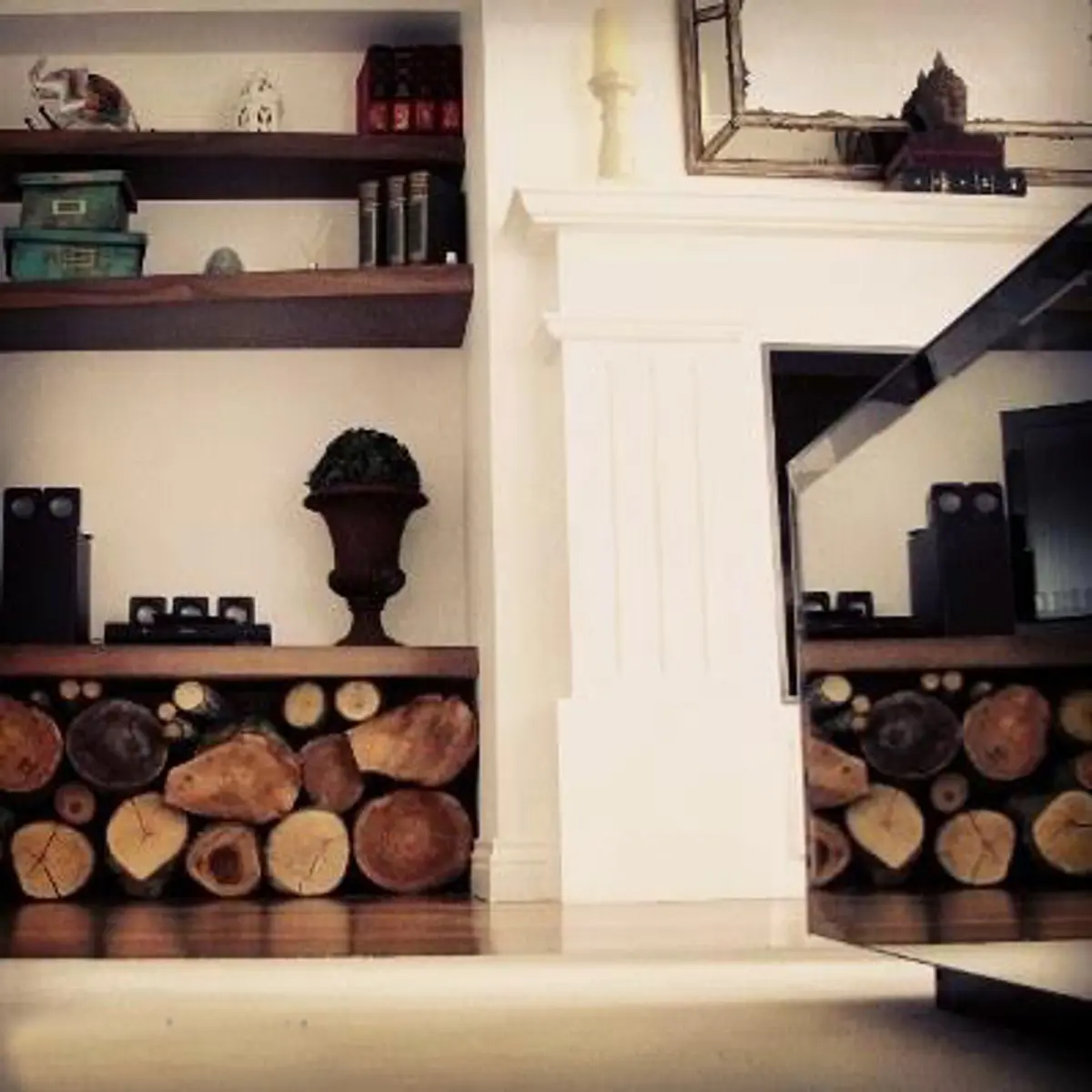Living con chimenea de piedra y estanterías de madera oscura — proyecto Casa VG, por Vicky Hurrell, en Mar del Plata