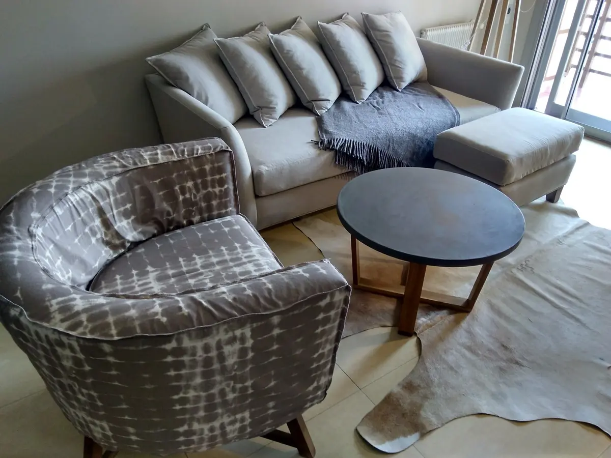 Living con sillones modernos y mesa de centro redonda — proyecto Departamento RA, por Vicky Hurrell, en Mar del Plata