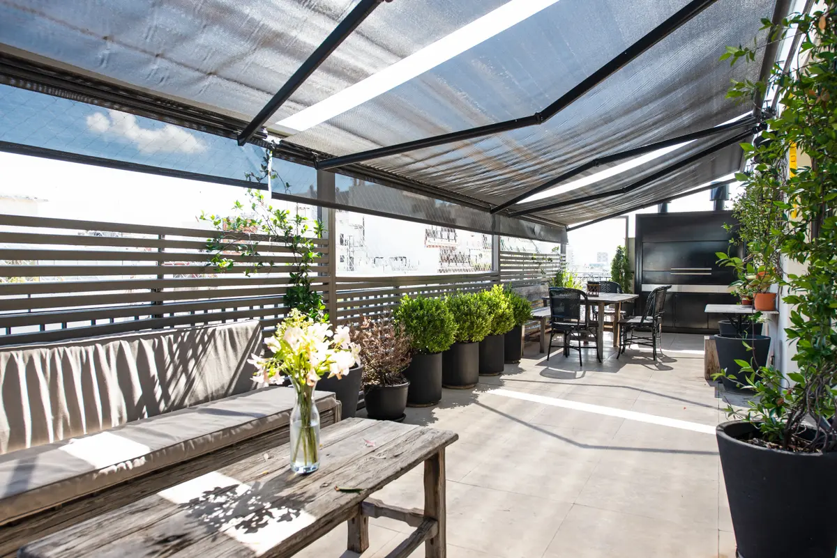 Terraço de varanda com pérgola de tecido e vegetação — projeto Quintana, por Escalante Vela Arquitectos, em CABA