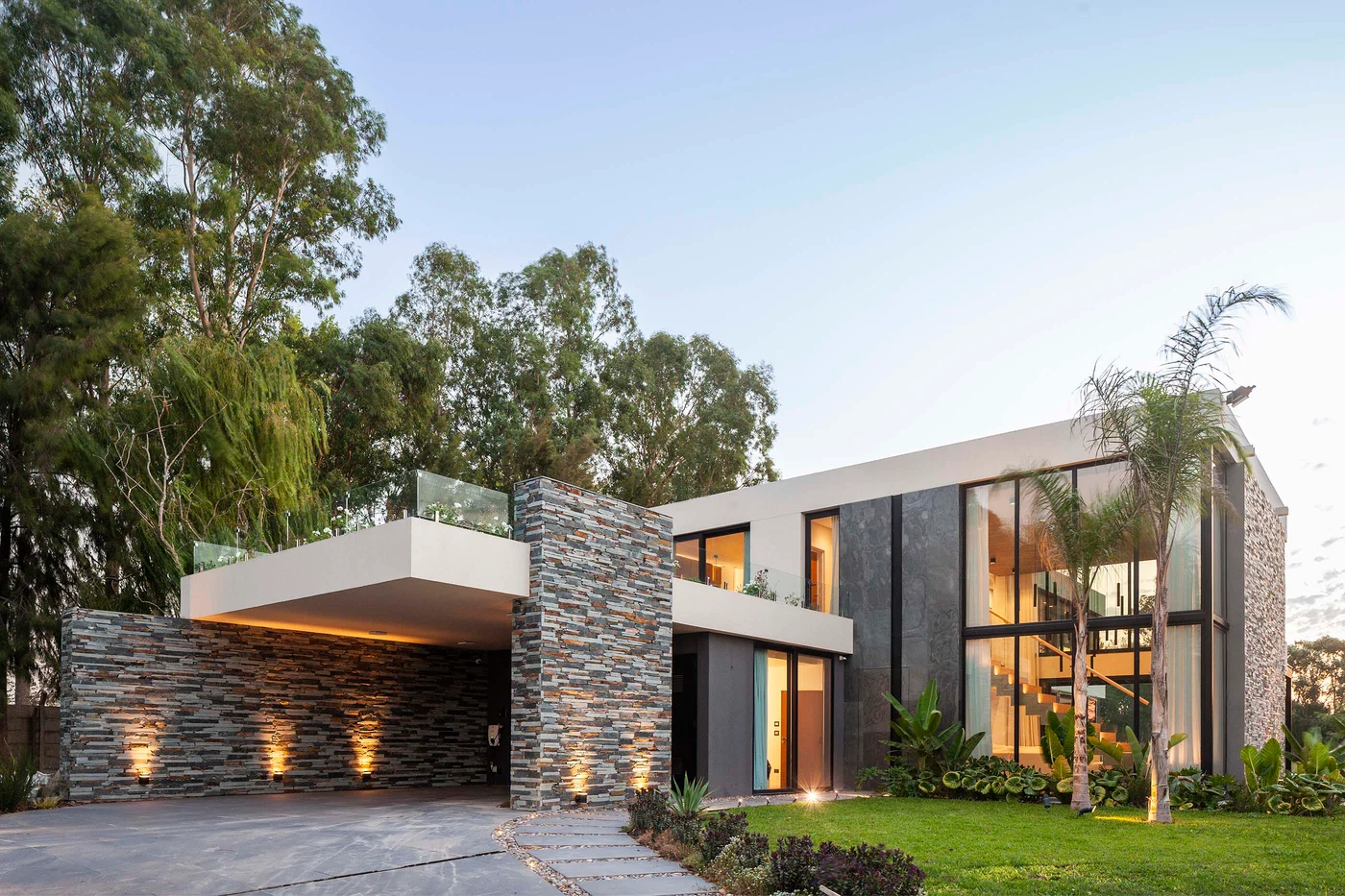 fachada moderna de dos pisos con piedra, madera y vidrio