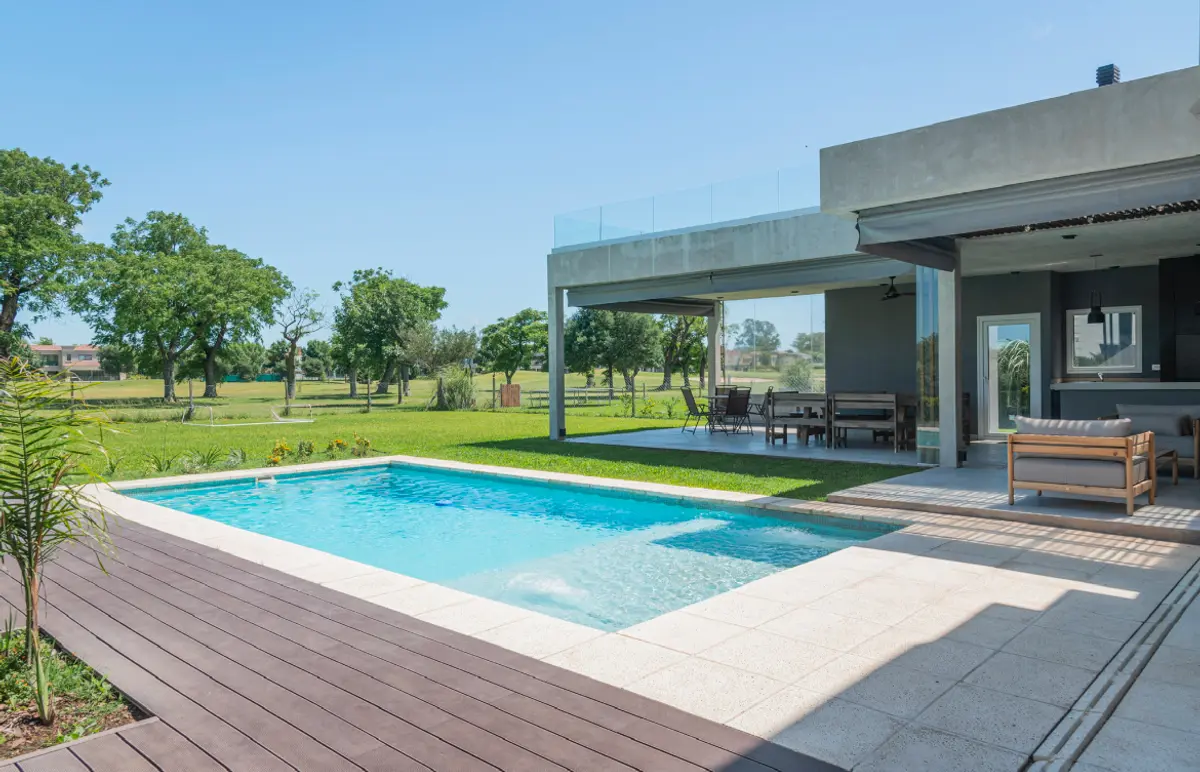 Moderna área de piscina residencial con deck de madera y vegetación exuberante — proyecto Reforma 1233, por Metro creativo , en Loma Verde