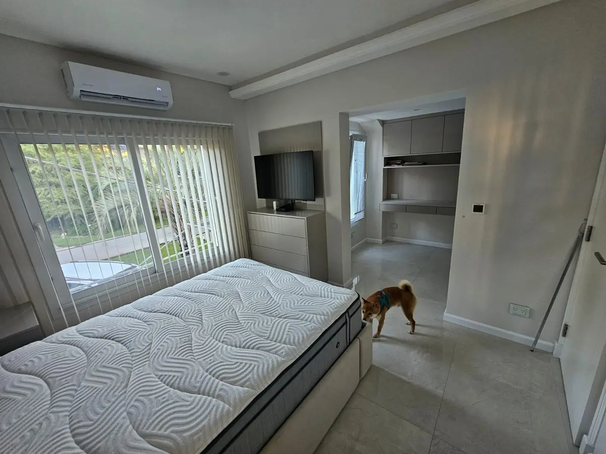 Dormitorio moderno con gran ventana y perro — proyecto Reforma V, por de Sautu Di Matteo arquitectos , en Canning