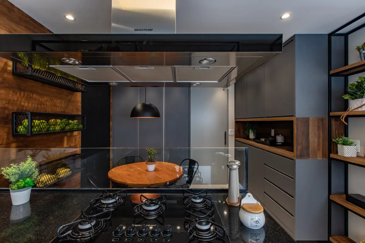 Cocina moderna con isla redonda, estufa negra y detalles en madera — proyecto Duo Morumbi, por Pricila Dalzochio