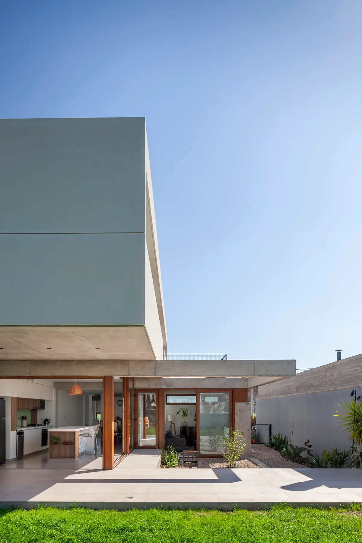Casa moderna de hormigón con patio interior y cocina integrada — proyecto CASA CV, por BUSCETTI & DI BERNARDO arquitectas, en Gonnet