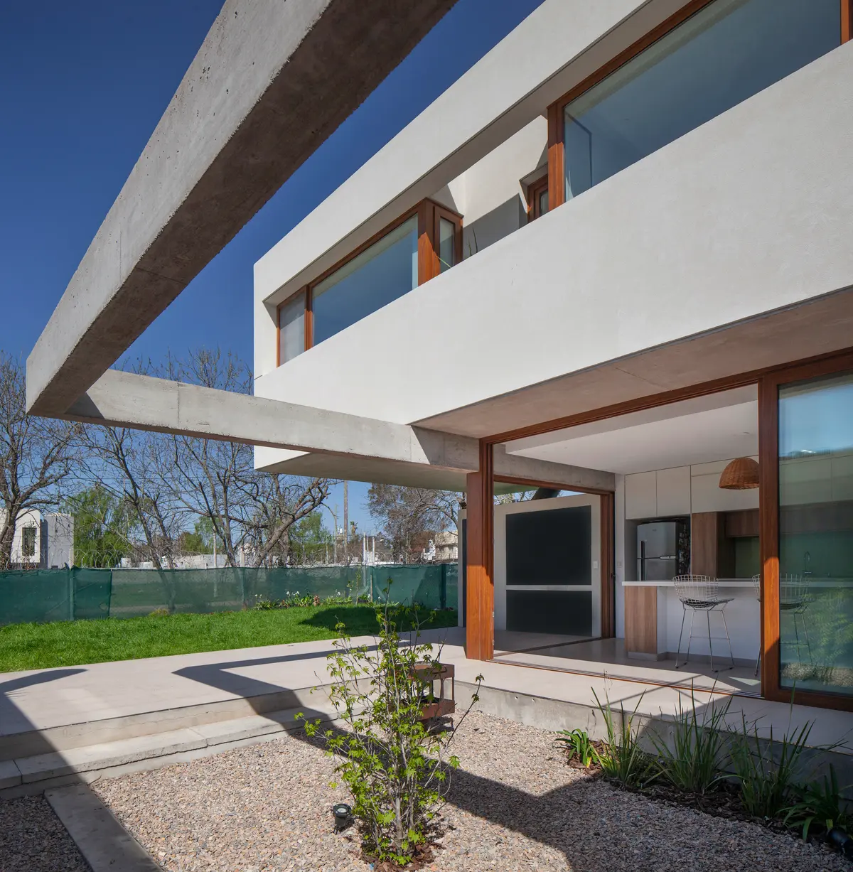 Casa moderna con viga de hormigón en voladizo y patio exterior — proyecto CASA CV, por BUSCETTI & DI BERNARDO arquitectas, en Gonnet