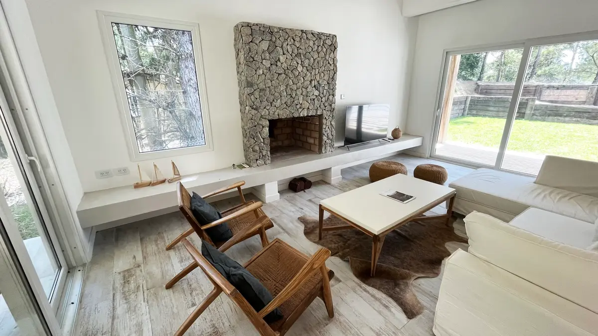 Living moderno con chimenea de piedra y ventanales amplios — proyecto Casa Luvir - Barrio Costa Esmeralda (Partido de la Costa, Buenos Aires) German S, por German Salas arquitectur