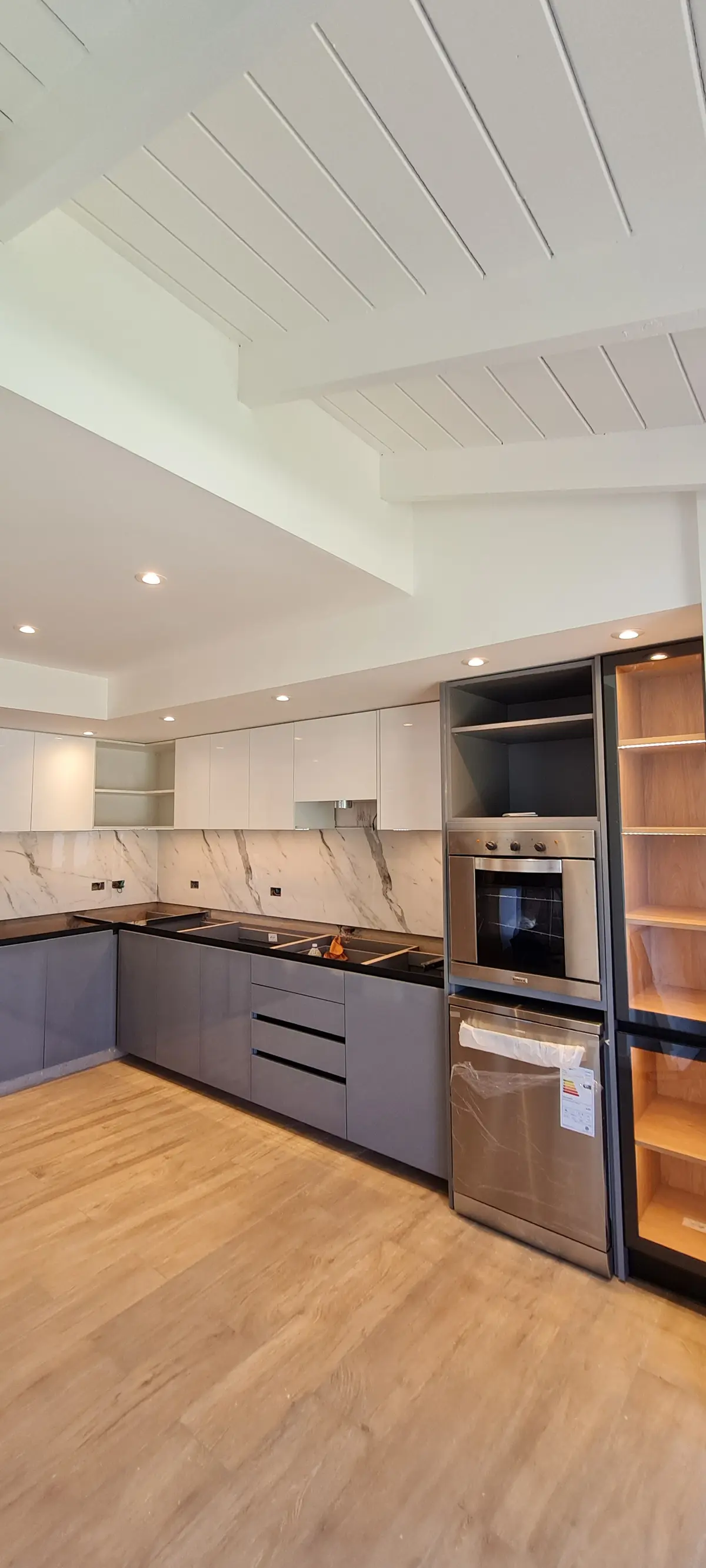 Cocina moderna con techo de madera y gabinetes blancos — proyecto Casa, por R-mod amoblamientos, en La Plata