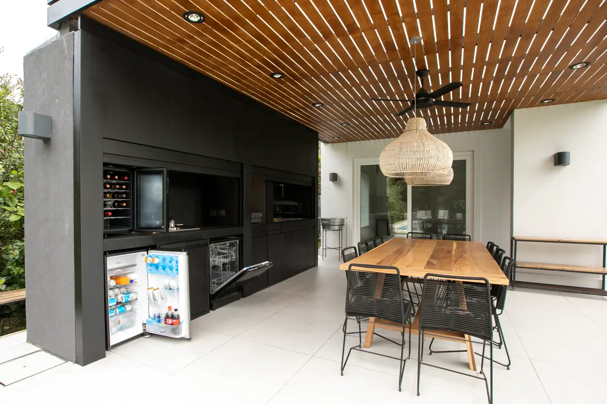 Espaço gourmet moderno com teto de madeira e churrasqueira integrada — projeto Obra Newman J, por Arq. Lourdes Yarade Saravia, em Benavidez