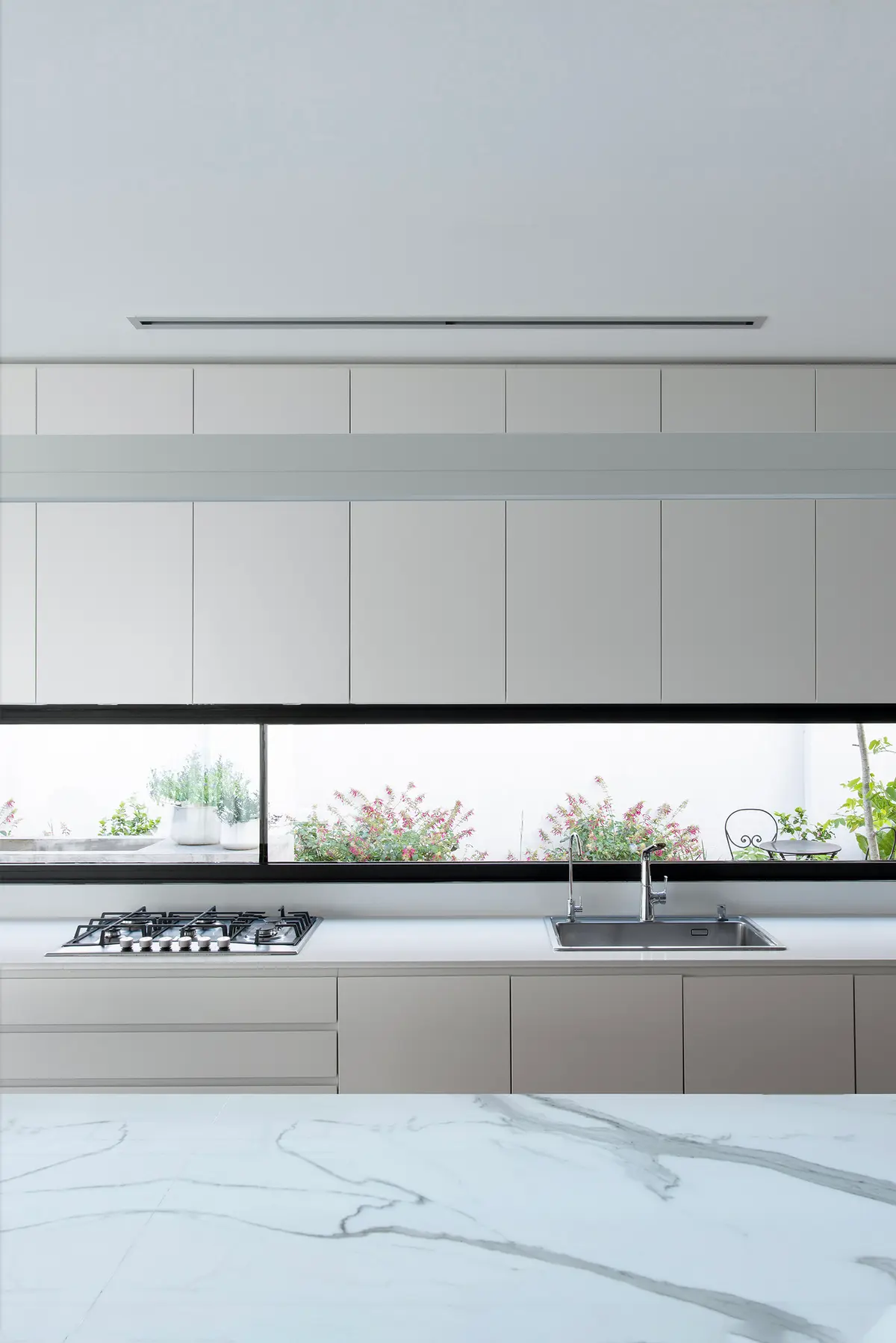 Cocina moderna minimalista con ventana panorámica y luz natural — proyecto CASA SD28, por GMARQ, en Buenos Aires