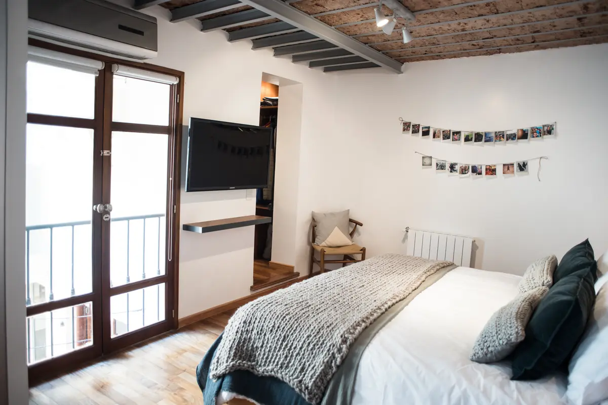 Dormitorio luminoso con vigas de madera a la vista y estilo escandinavo — proyecto Defensa, por Estudio Basa, en CABA