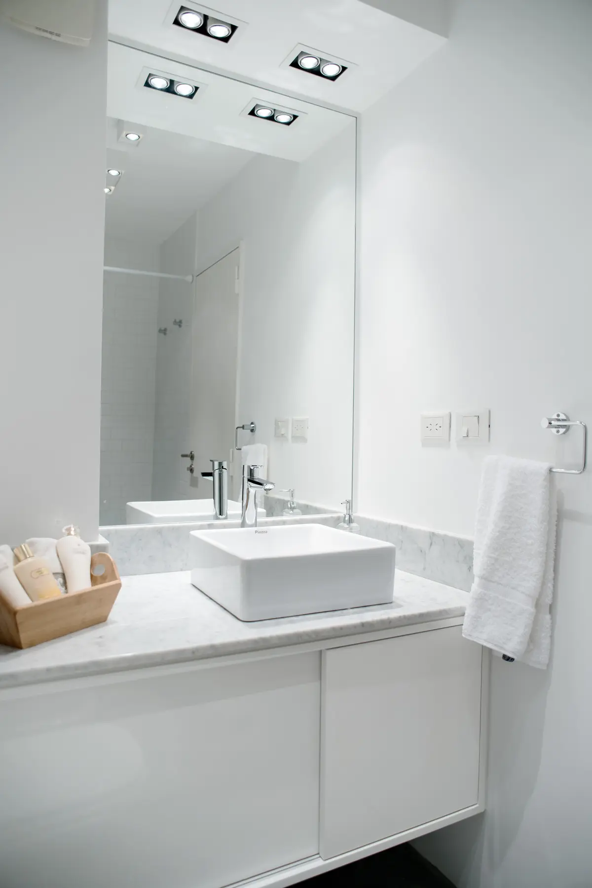 Baño moderno con bacha cuadrada sobre mesada de mármol y luces indirectas — proyecto República de la India, por Estudio Basa, en Palermo
