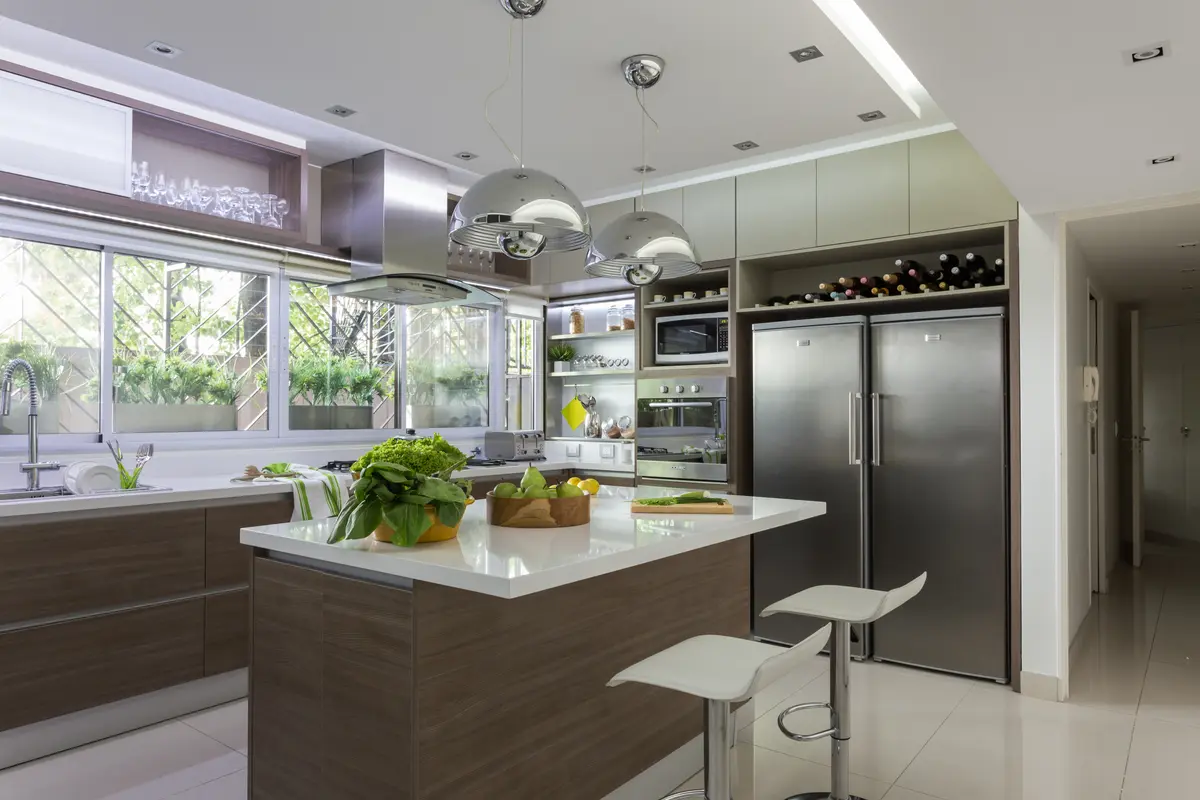 Cocina moderna con isla grande, ventanales y luces colgantes — proyecto Piso en Belgrano II, por Gutman+Lehrer Arquitectas, en Belgrano