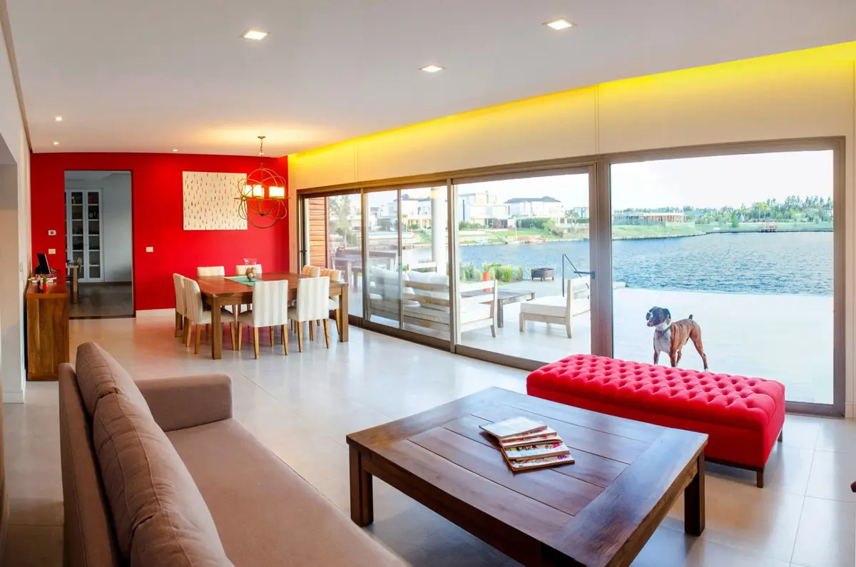 Living comedor moderno con vista al mar y luz cálida indirecta — proyecto Casa Nordelta, por linearecta.arquitectura, en Nordelta