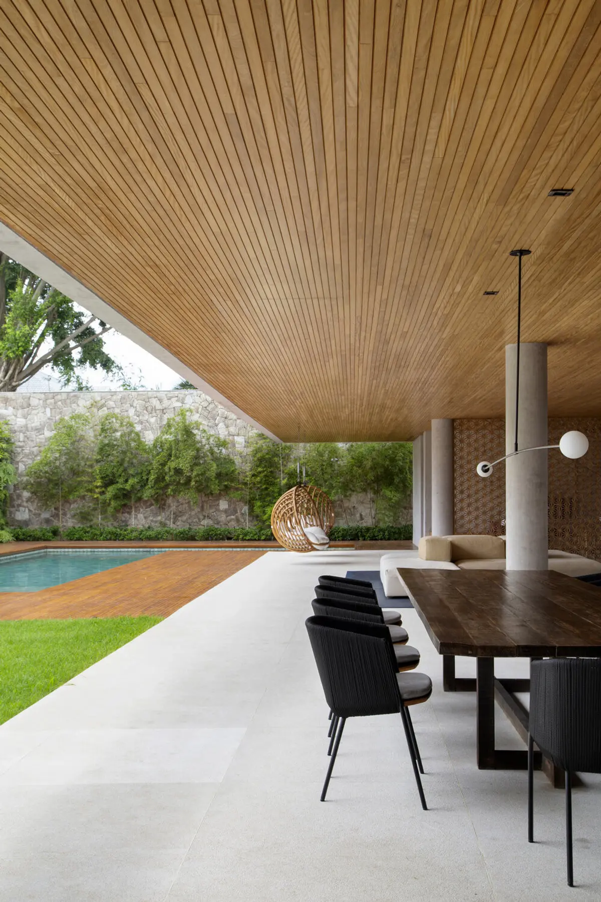 Galeria cubierta moderna junto a pileta con techo madera y mobiliario negro — proyecto BM House, por Studio Ro-ca