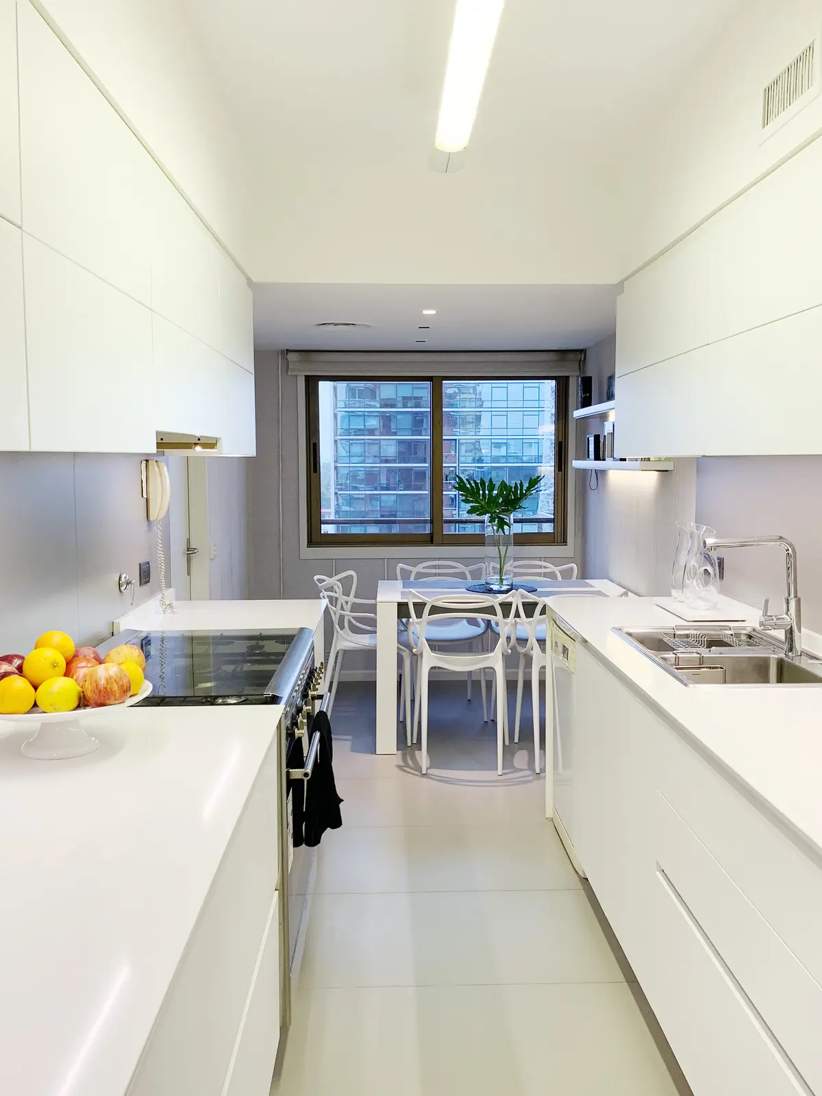 Cocina minimalista blanca con isla, mesada continua y ventanal — proyecto Obra Reforma Cocina Sucre , por @estudioVivianaStaro