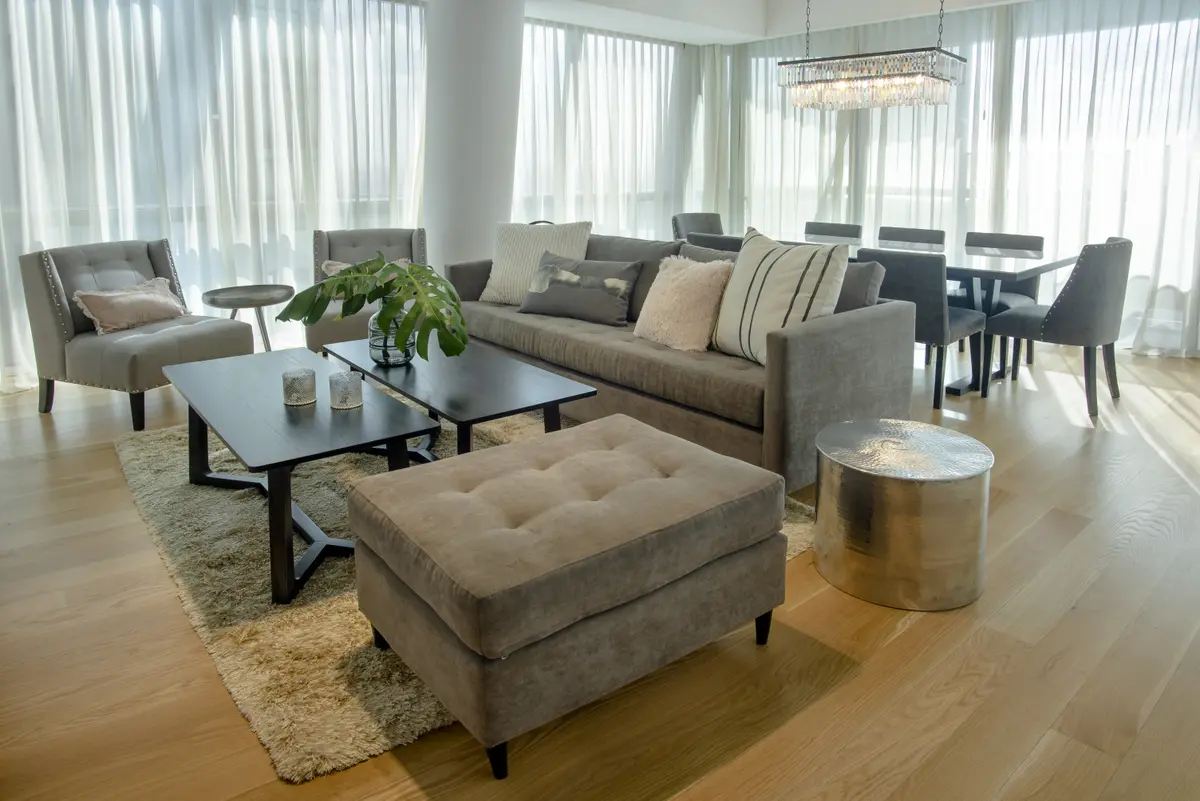 Living moderno con cortinas blancas, suelo de madera y sofá modular — proyecto Alvear Icon, por Linea D Interiorismo, en CABA