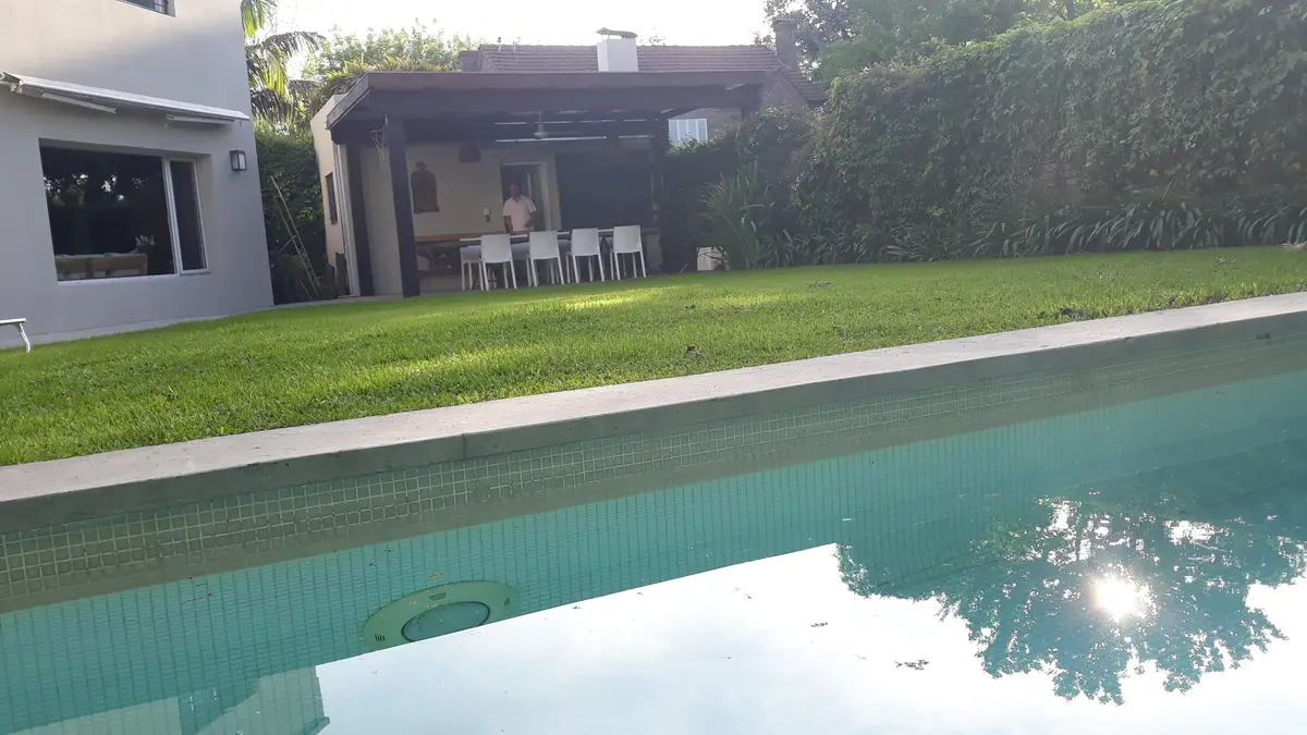 Piscina moderna con área de estar integrada y sector de comedor exterior — proyecto Obra Carlos Gardel, por Arq. Lourdes Yarade Saravia, en San Isidro