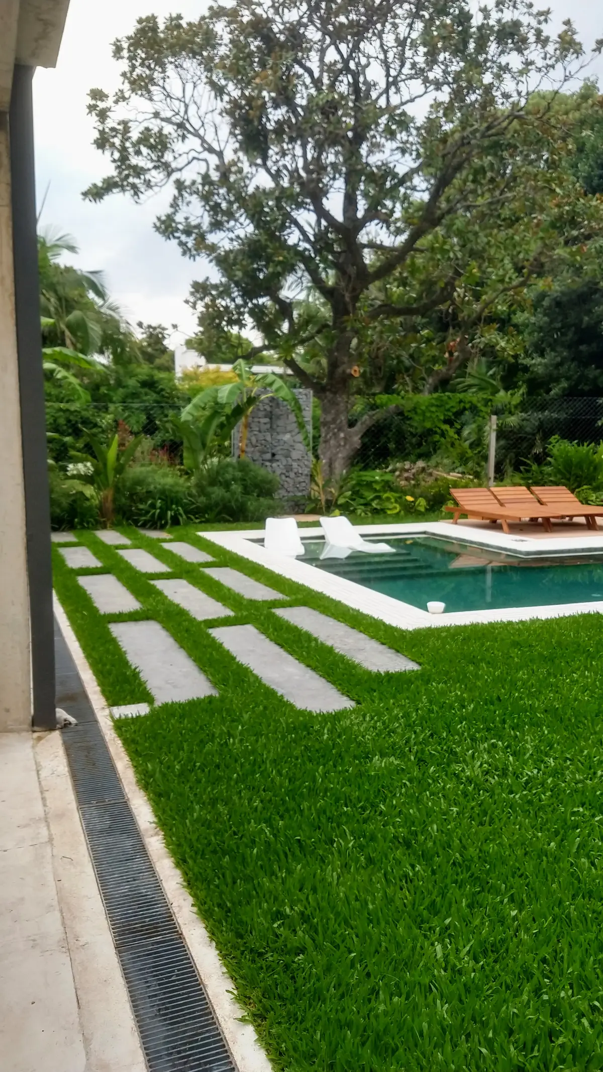 área de piscina moderna con camino de losas y césped — proyecto Ladislao_EA, por Eugenia Anaya -estudio de paisajismo-, en B1641 Acassuso