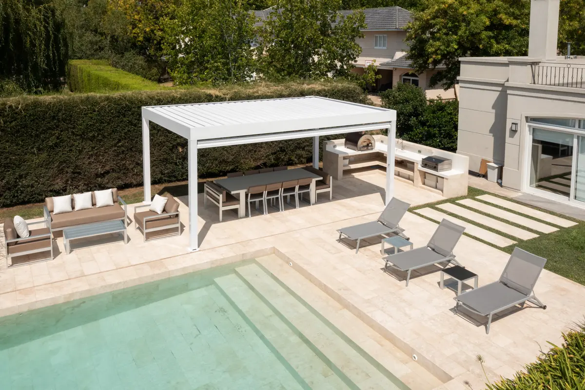 Área de piscina moderna com pérgola branca e móveis externos cinzas — projeto TOLDER - PERGOLAS, por Argentina en Obra 2024, em Rincón de Milberg