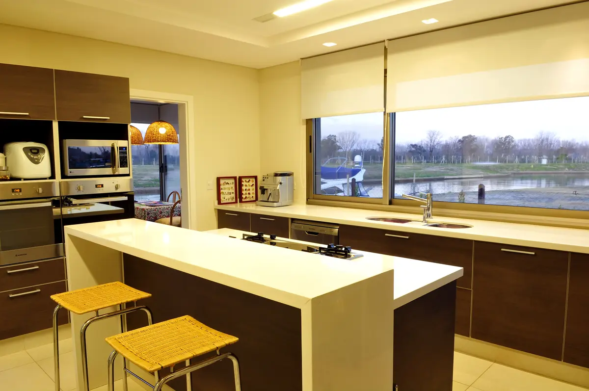 Cozinha moderna com ilha grande e janela panorâmica — projeto Moderna Seducción, por Apaarquitectura, em Tigre