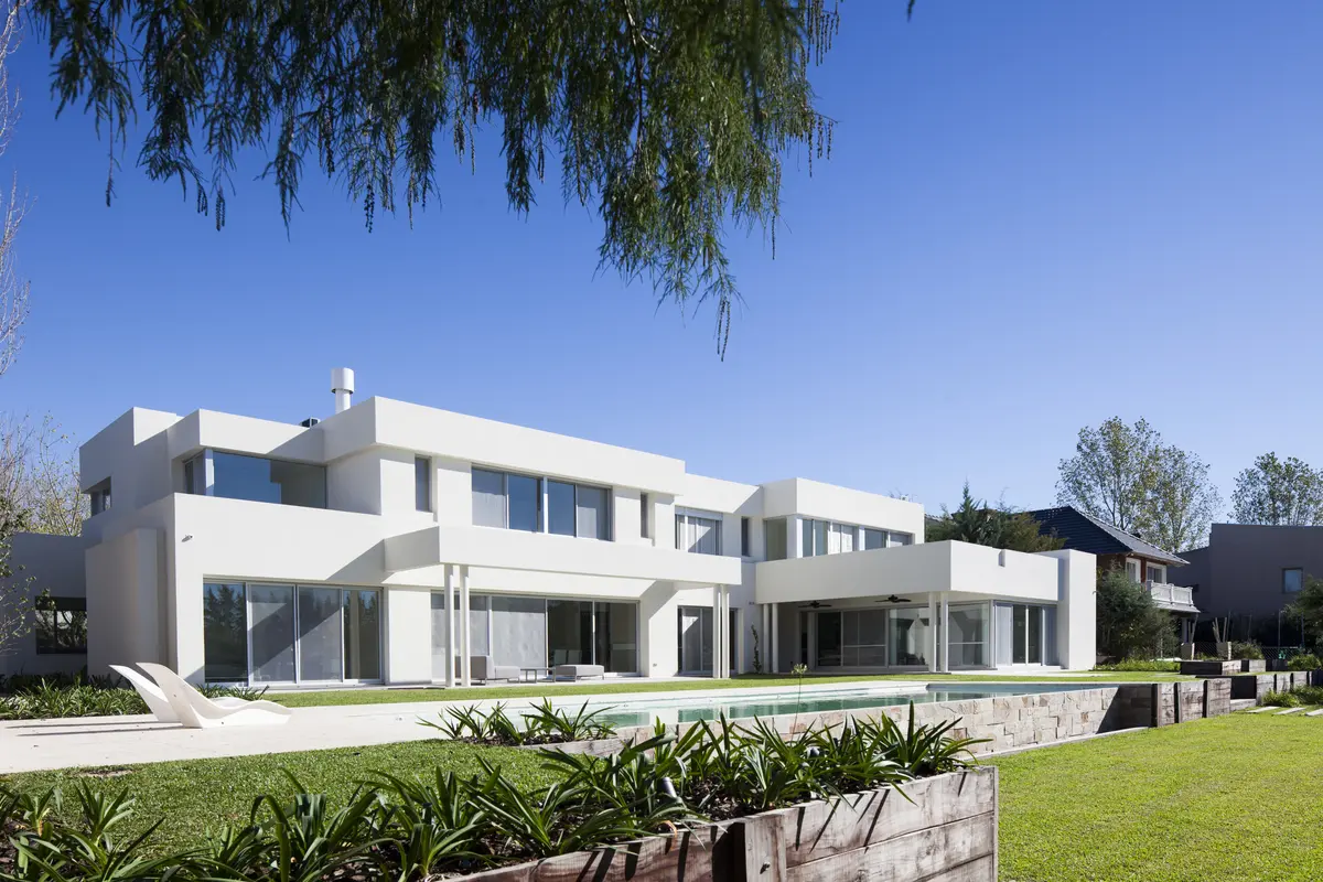 Fachada moderna imponente com amplas janelas e piscina — projeto Modernismo Náutico, por Apaarquitectura, em Tigre