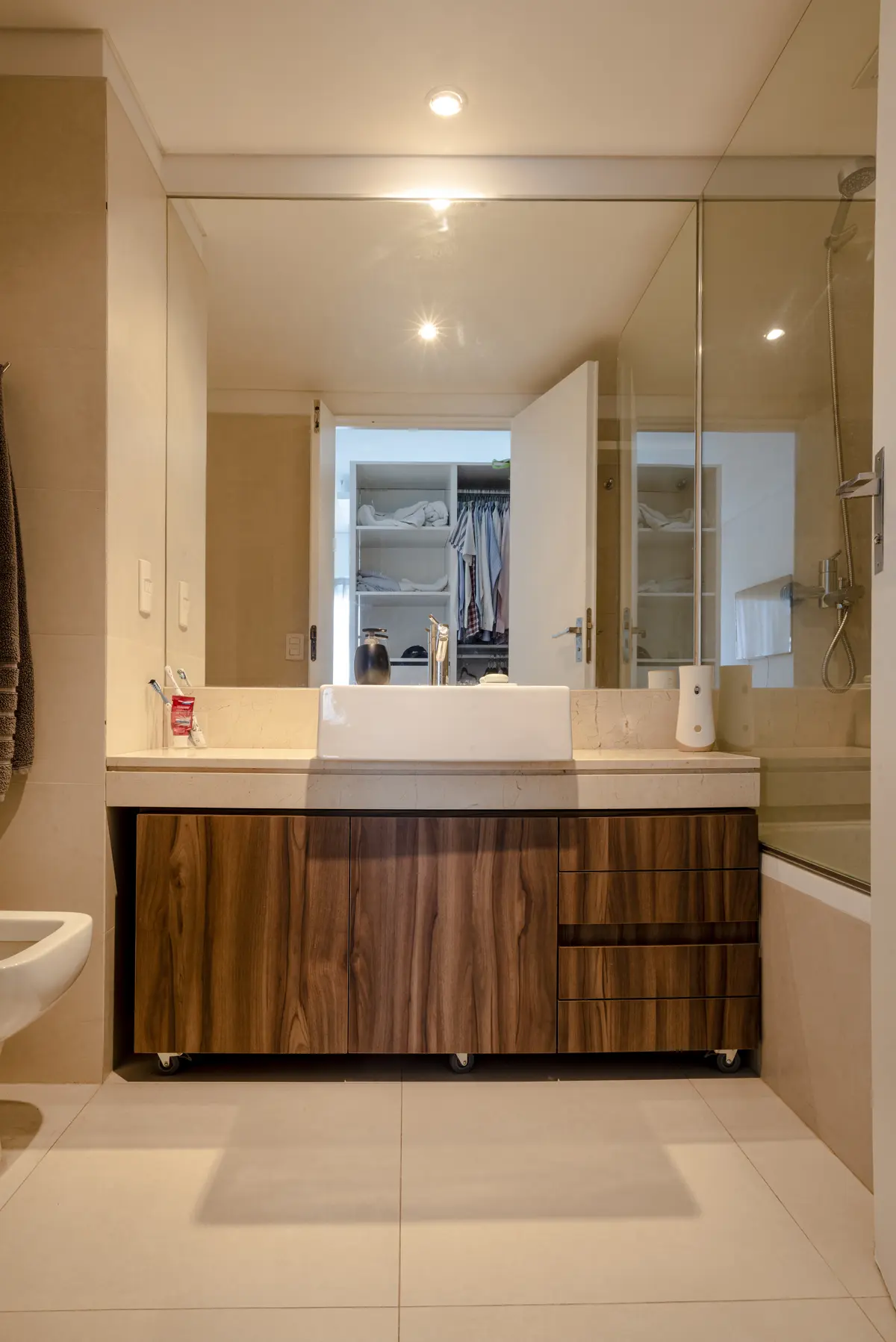 Baño moderno con mueble de madera, lavabo sobre encimera y espejo grande — proyecto Libertador, por ST Arquitectas, en CABA