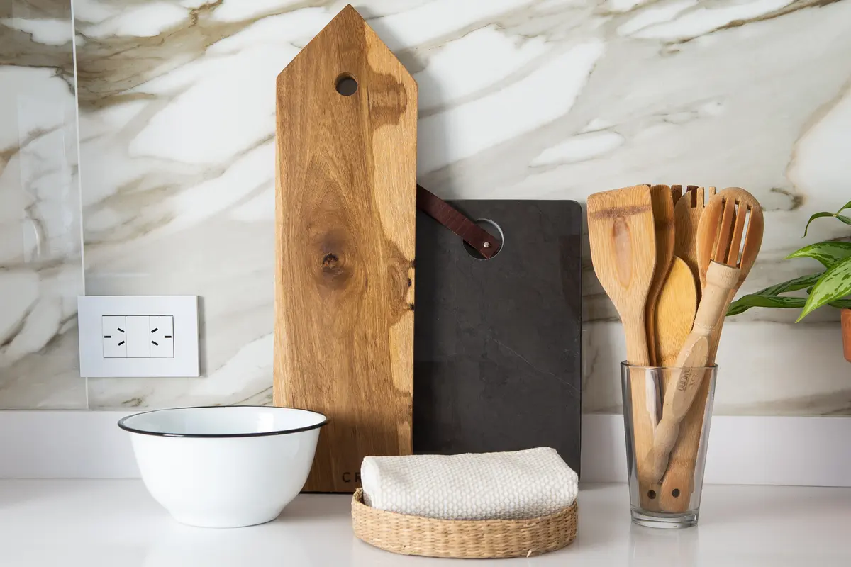 Cocina moderna con pared de mármol y utensilios de madera — proyecto Altolaguirre, por Estudio Plok, en CABA
