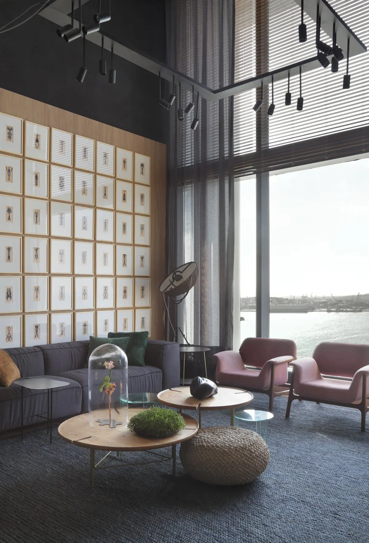 Living moderno con ventanal al río, sofá gris y sillones burdeos — proyecto Casa COR 2017, por Studio Ro-ca
