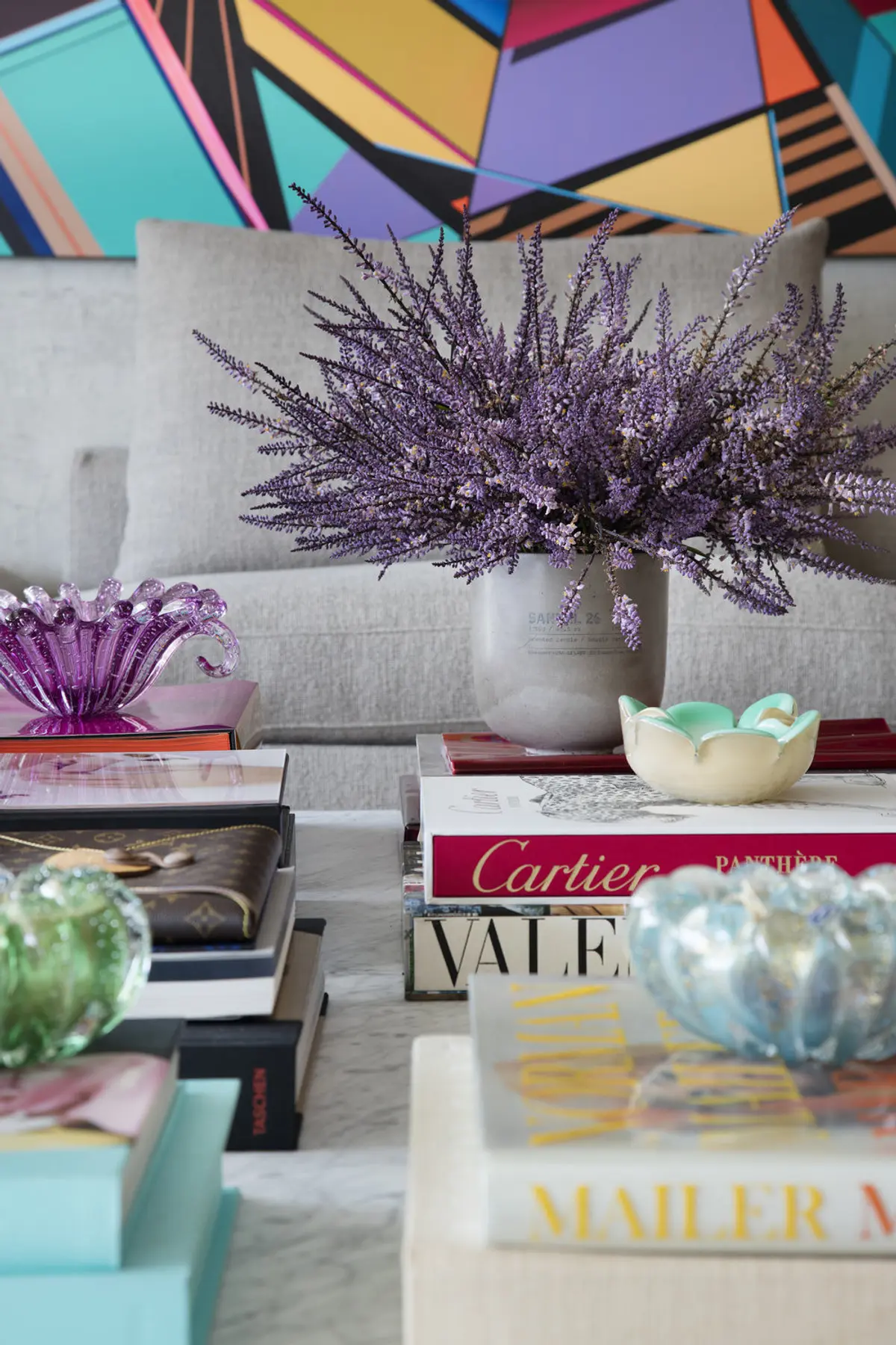 Living con sofá gris, flores secas púrpura y mural colorido de fondo — proyecto RM House, por Studio Ro-ca