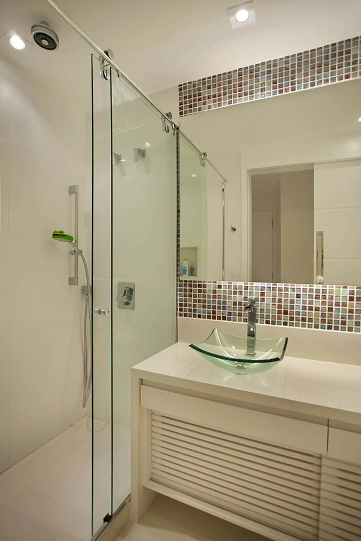 Baño moderno con ducha vidrio, mesada marmol blanca y azulejos decorativos — proyecto Apartamento Recreio, por Amanda Miranda