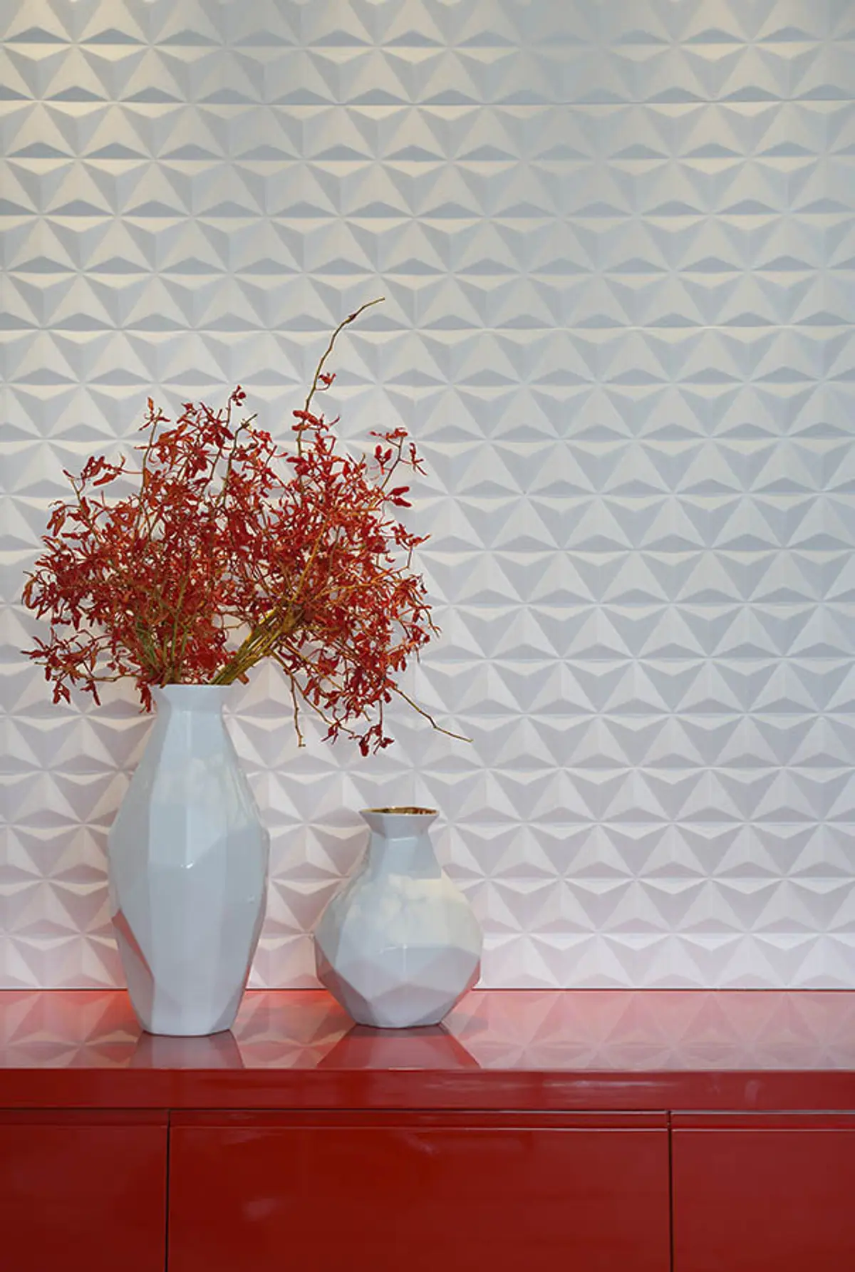 Arreglo minimalista con flores rojas secas en jarrón blanco sobre mueble rojo — proyecto Casa Blue House, por Amanda Miranda
