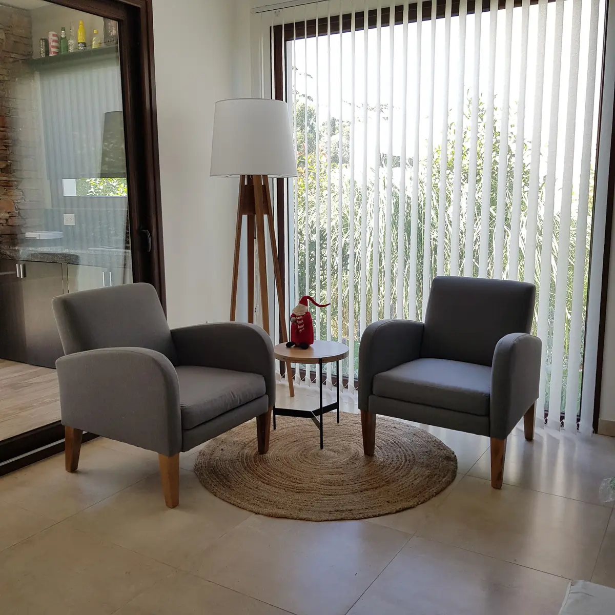 Sala de estar moderna con dos sillones grises y gran ventana — proyecto Casa FA, por Vicky Hurrell, en Mar del Plata