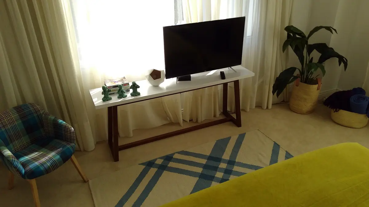 Living moderno con sillón a cuadros y mesa larga — proyecto Casa VG, por Vicky Hurrell, en Mar del Plata