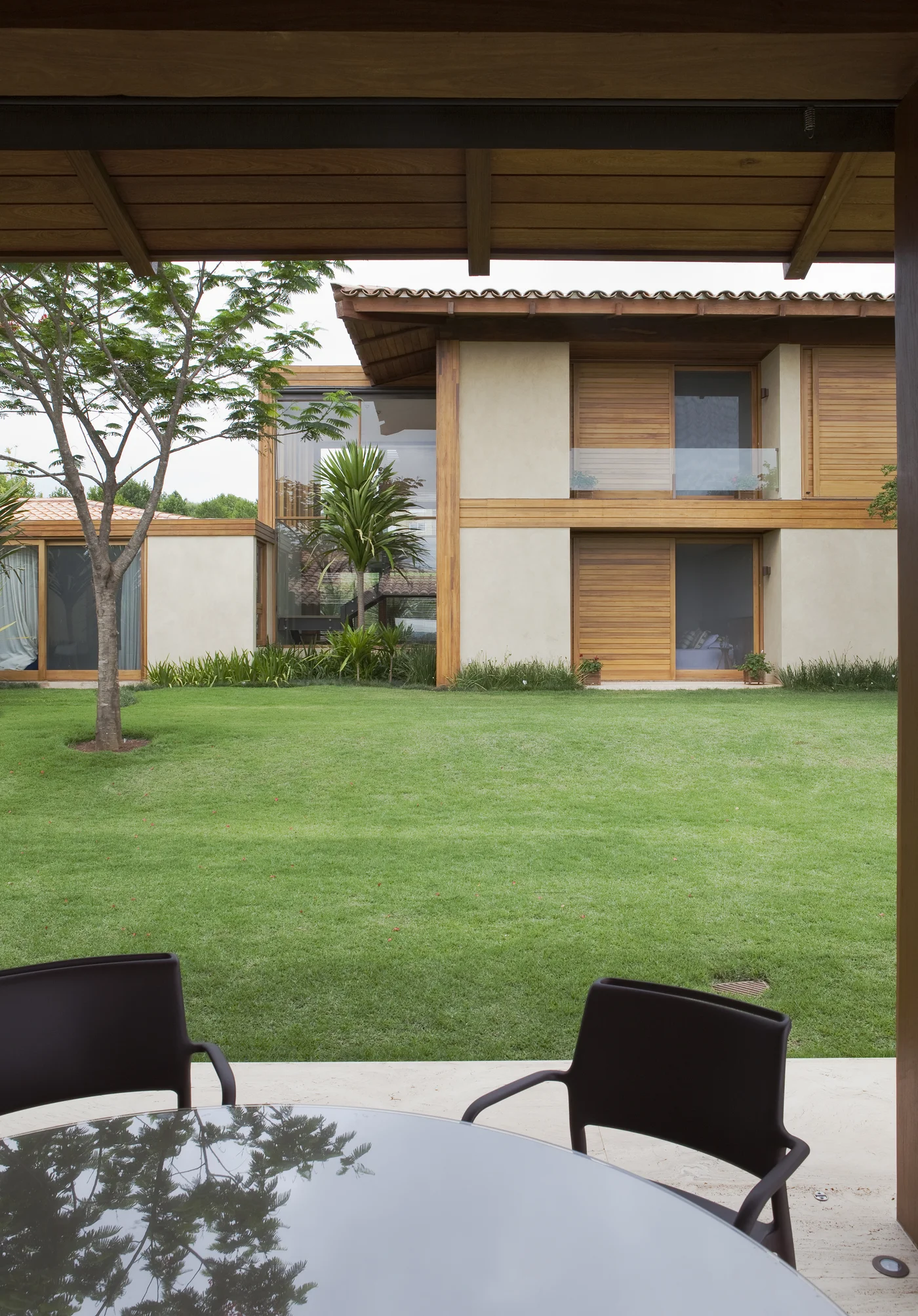 Casa moderna con jardín verde y comedor exterior
