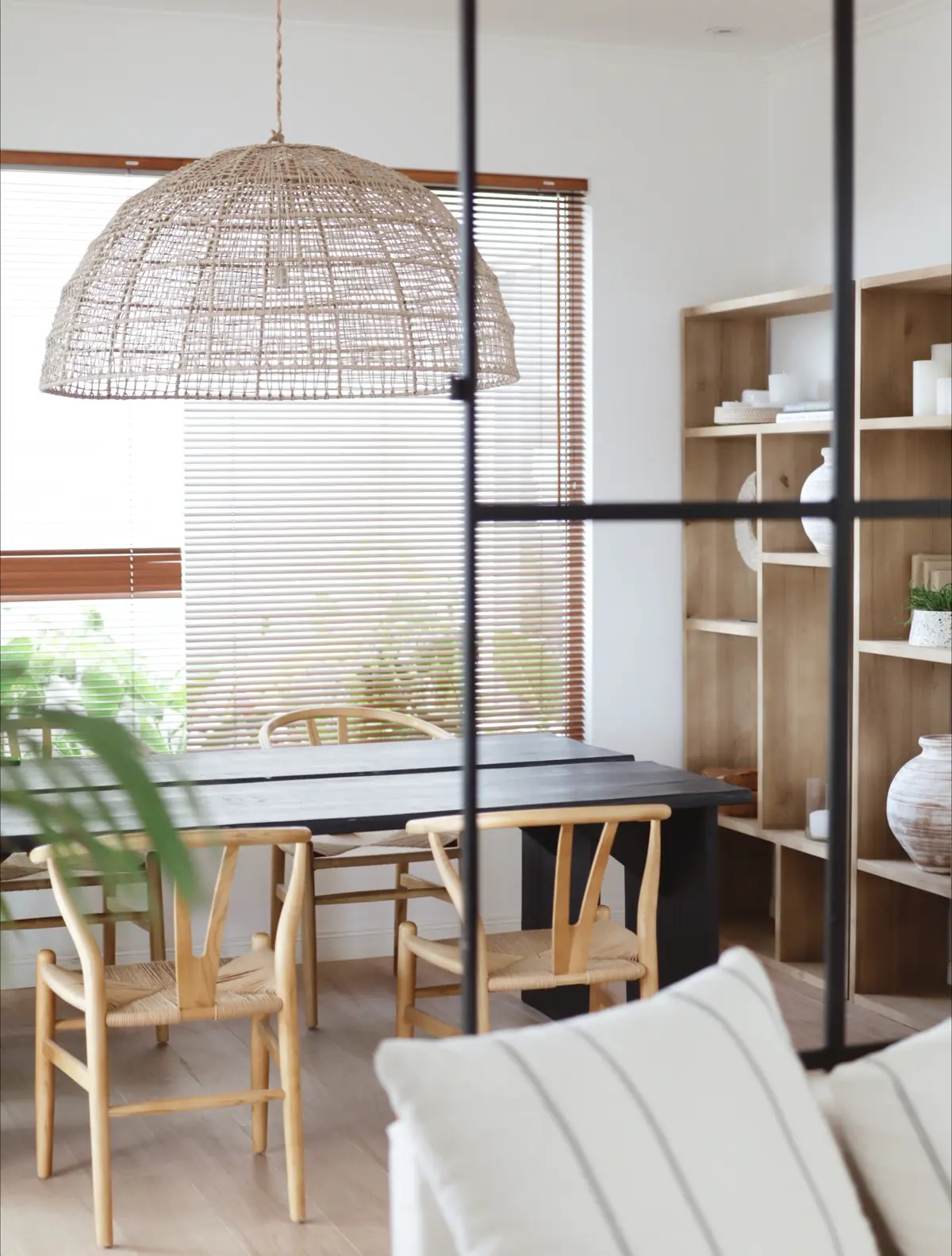 Sala de jantar com pendente de vime, cadeiras wishbone e prateleiras — projeto SPD, por Grupo Pauta Arquitectura