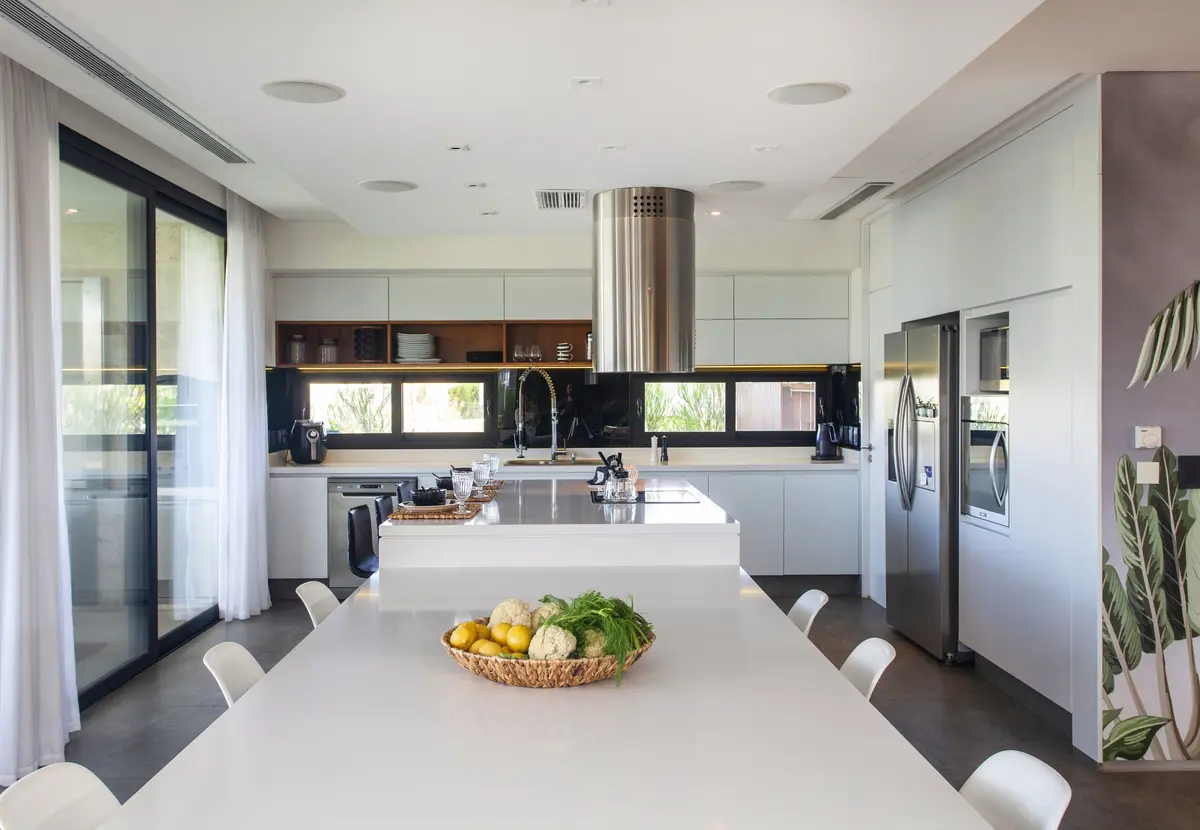 Cozinha moderna aberta com ilha de mármore e madeira — projeto Casa BJM, por Vanguarda Arquitectos, em Belén de Escobar