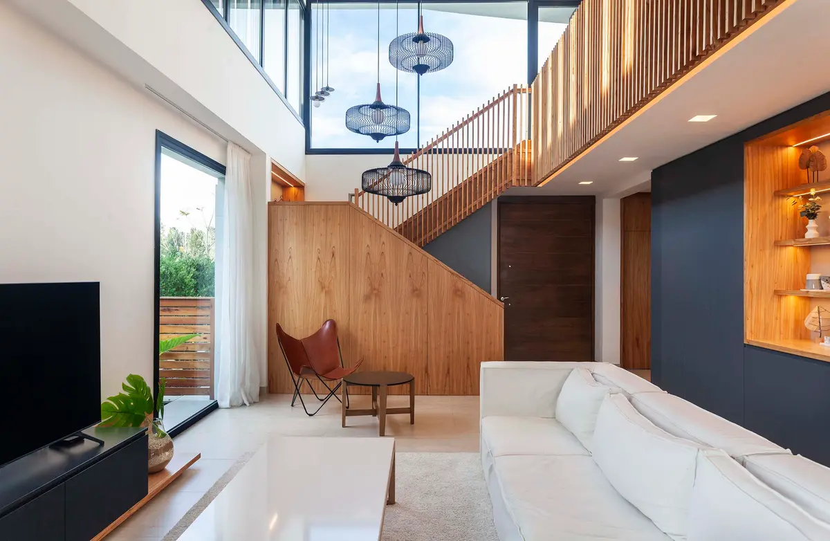 Sala de estar moderna com pé-direito duplo, madeira e pendentes — projeto Castaños, por GO arquitectos, em Rincón de Milberg
