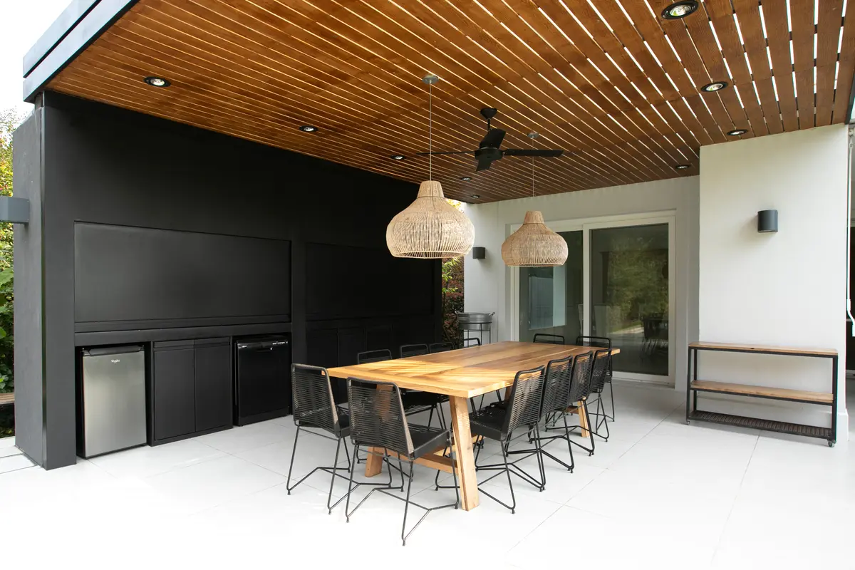 Sala de jantar externa moderna com teto de madeira e luminárias de vime — projeto Obra Newman J, por Arq. Lourdes Yarade Saravia, em Benavidez
