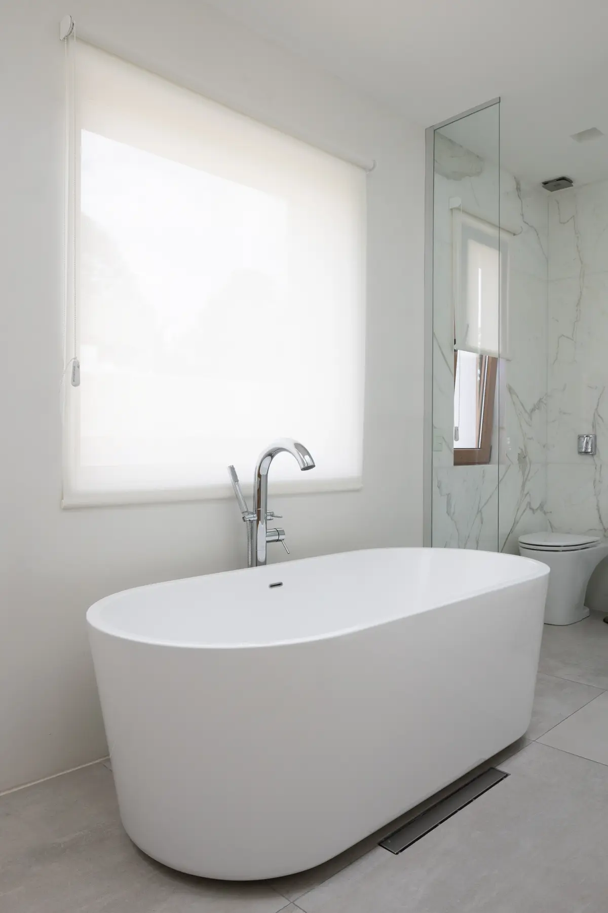 Baño moderno con bañera exenta blanca y grifería de suelo — proyecto CASA OrAz, por Alfredo Orfila arquitectura, en San Isidro