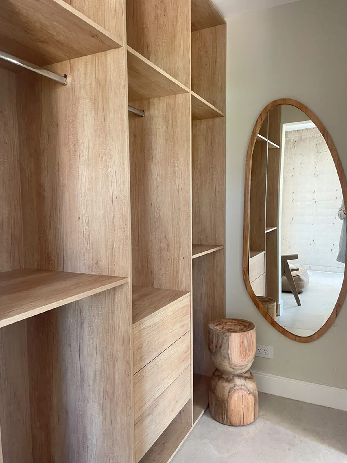 Amplio vestidor de madera natural con espejo ovalado y taburete tallado — proyecto El Secreto, por Grupo Pauta Arquitectura, en Tigre