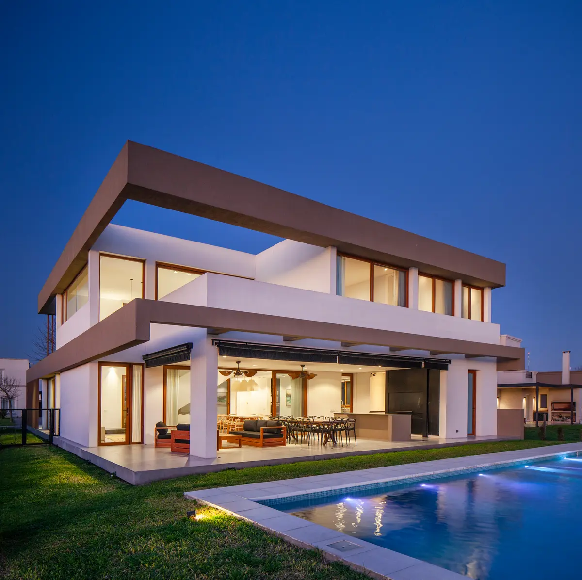 Fachada moderna com piscina e madeira escura — projeto Casa Green, por Frato construcciones, em Belén de Escobar