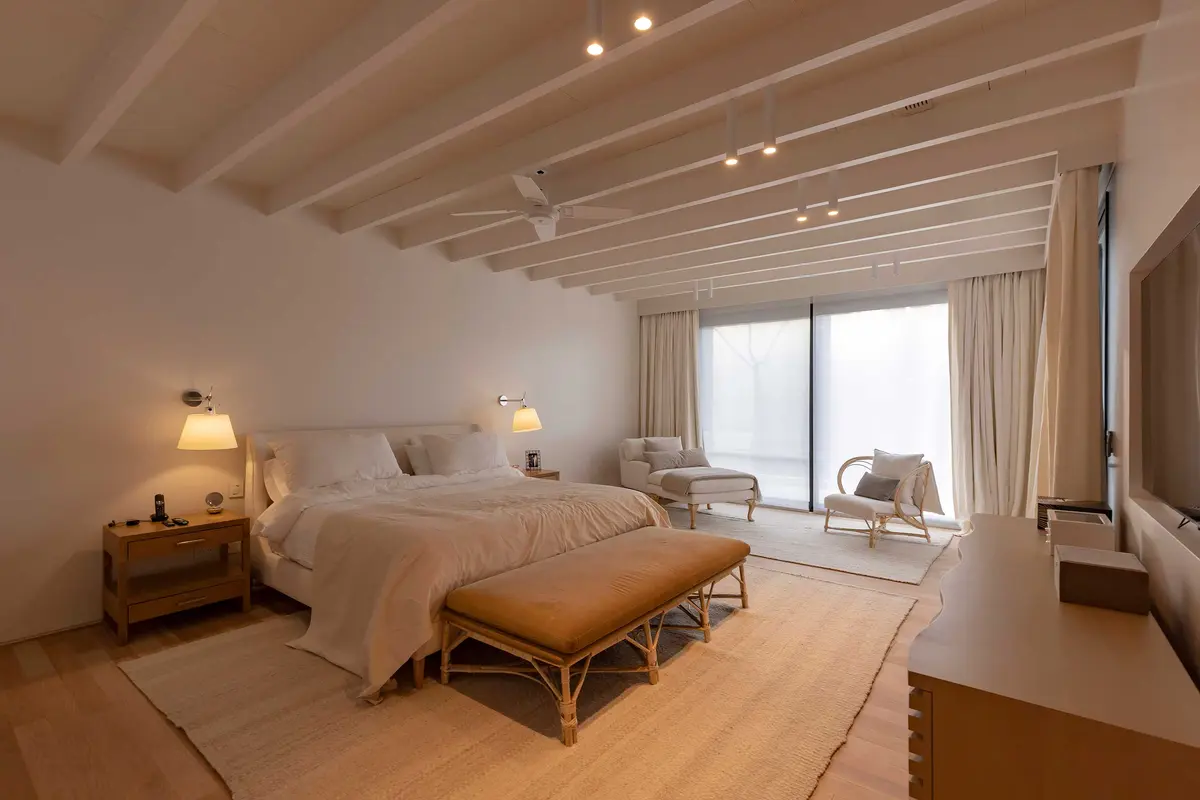 Dormitorio moderno con vigas expuestas y grandes ventanales — proyecto Las Marías, por Santiago Cordeyro Arquitectos, en San Isidro