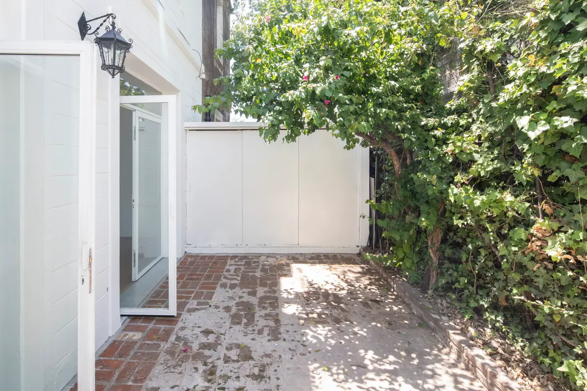 Fachada moderna con patio y vegetación exuberante — proyecto Reforma Alsina, por Estudio YME, en San Isidro
