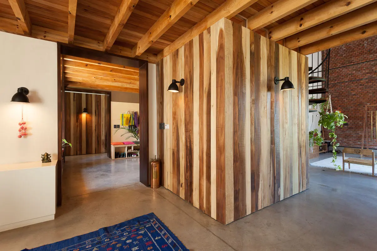 Pasillo de ingreso con tabiques de madera y doble altura — proyecto Casa Lujan _AB Estudio, por Estudio MiGO