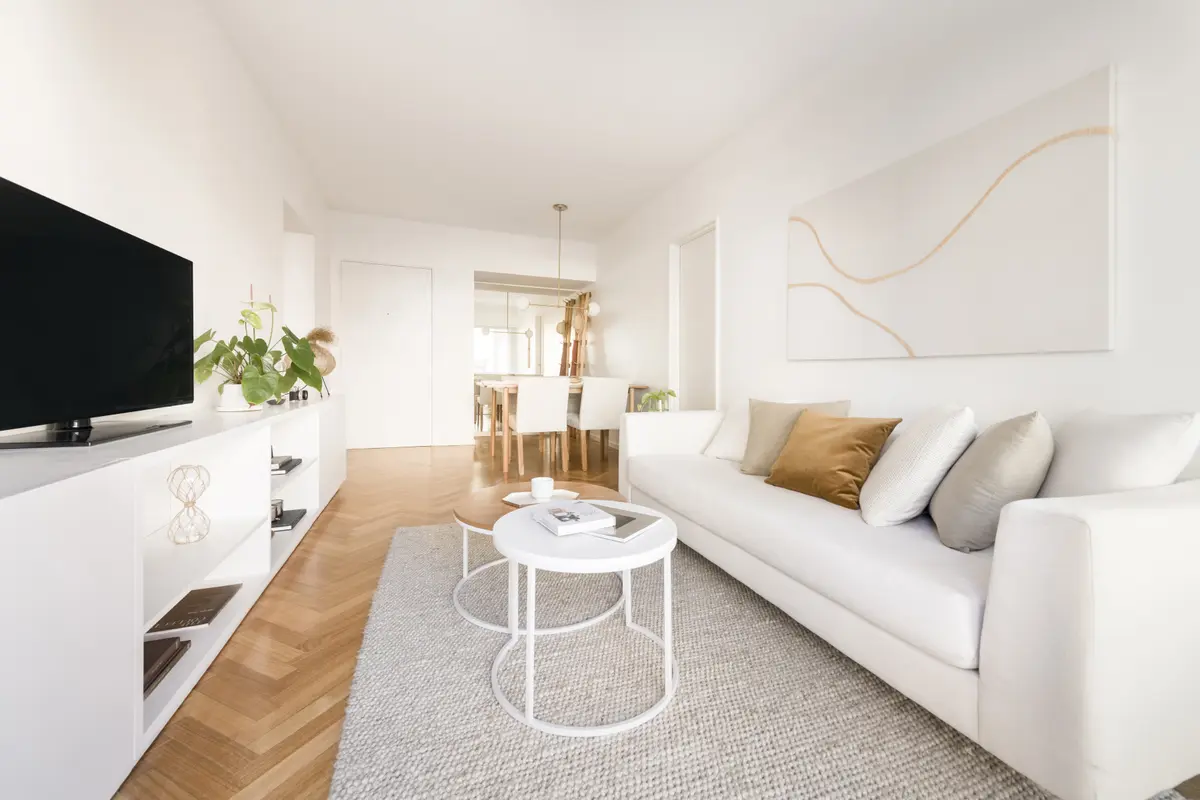Sala de estar moderna com sofá branco modular e piso de madeira — projeto Cerviño, por Estudio Basa, em CABA
