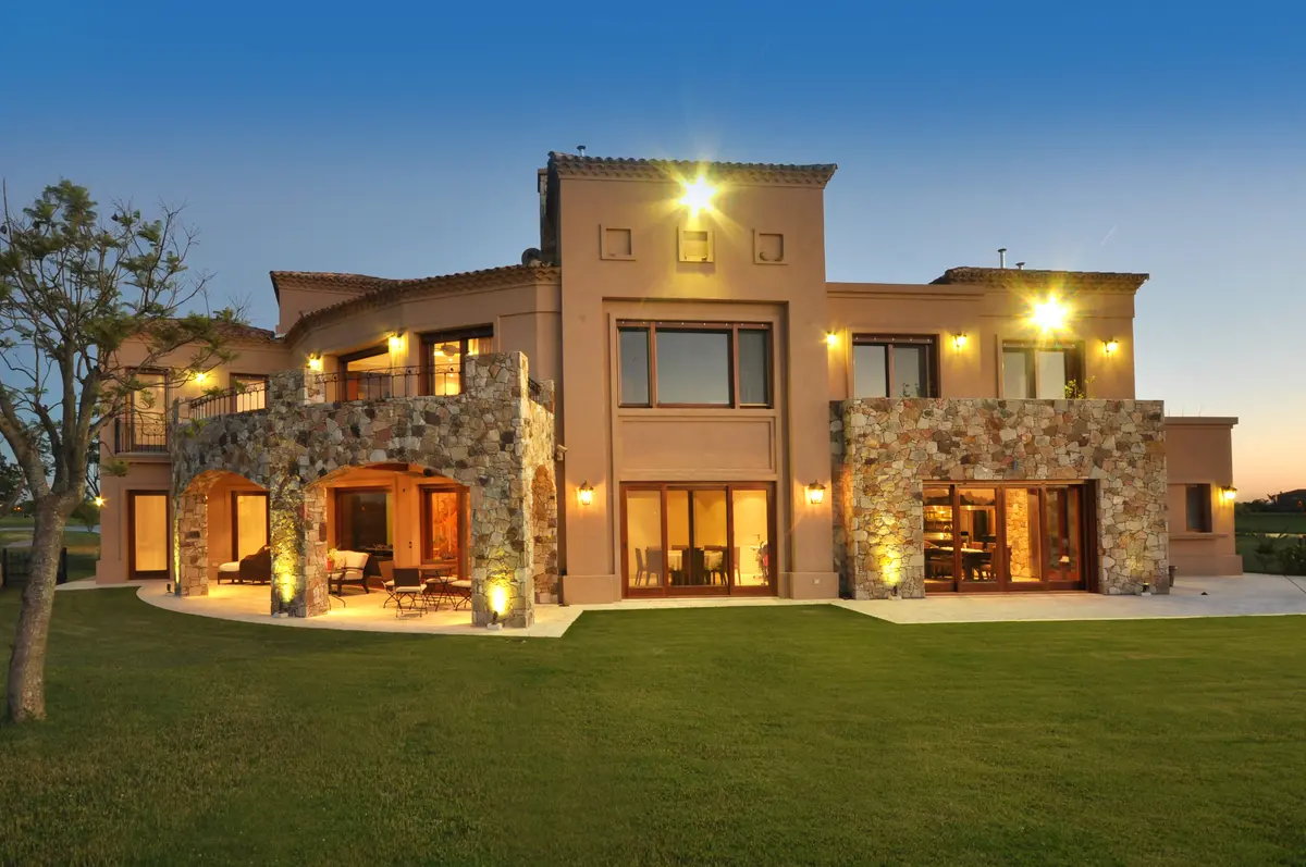 fachada moderna estilo mediterrâneo com pedra e arcos — projeto Toscana al Golf, por Apaarquitectura