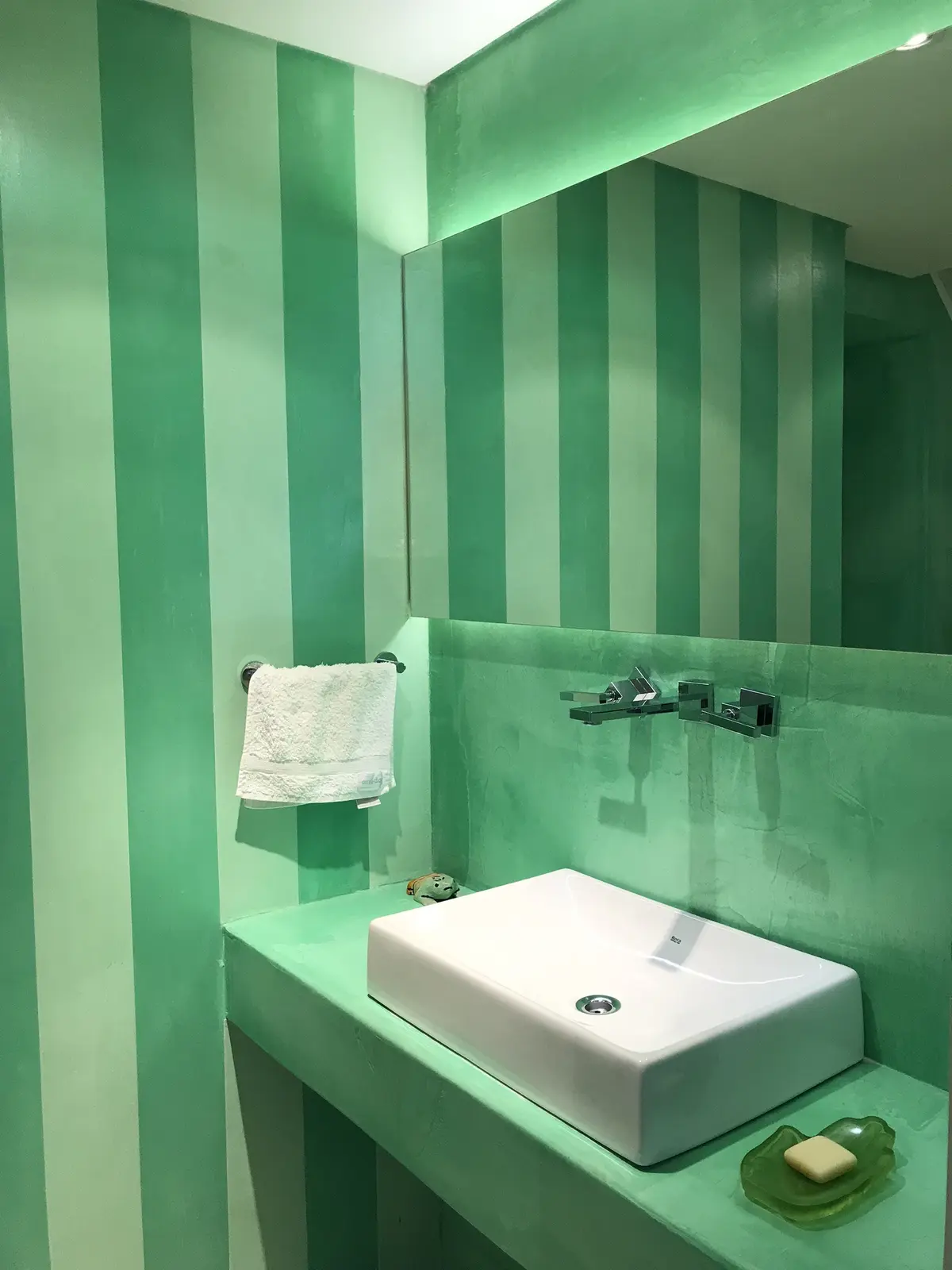 Baño moderno con paredes a rayas verdes y lavamanos blanco rectangular — proyecto Monroe - La Horqueta, por Mgc.arq, en La Horqueta
