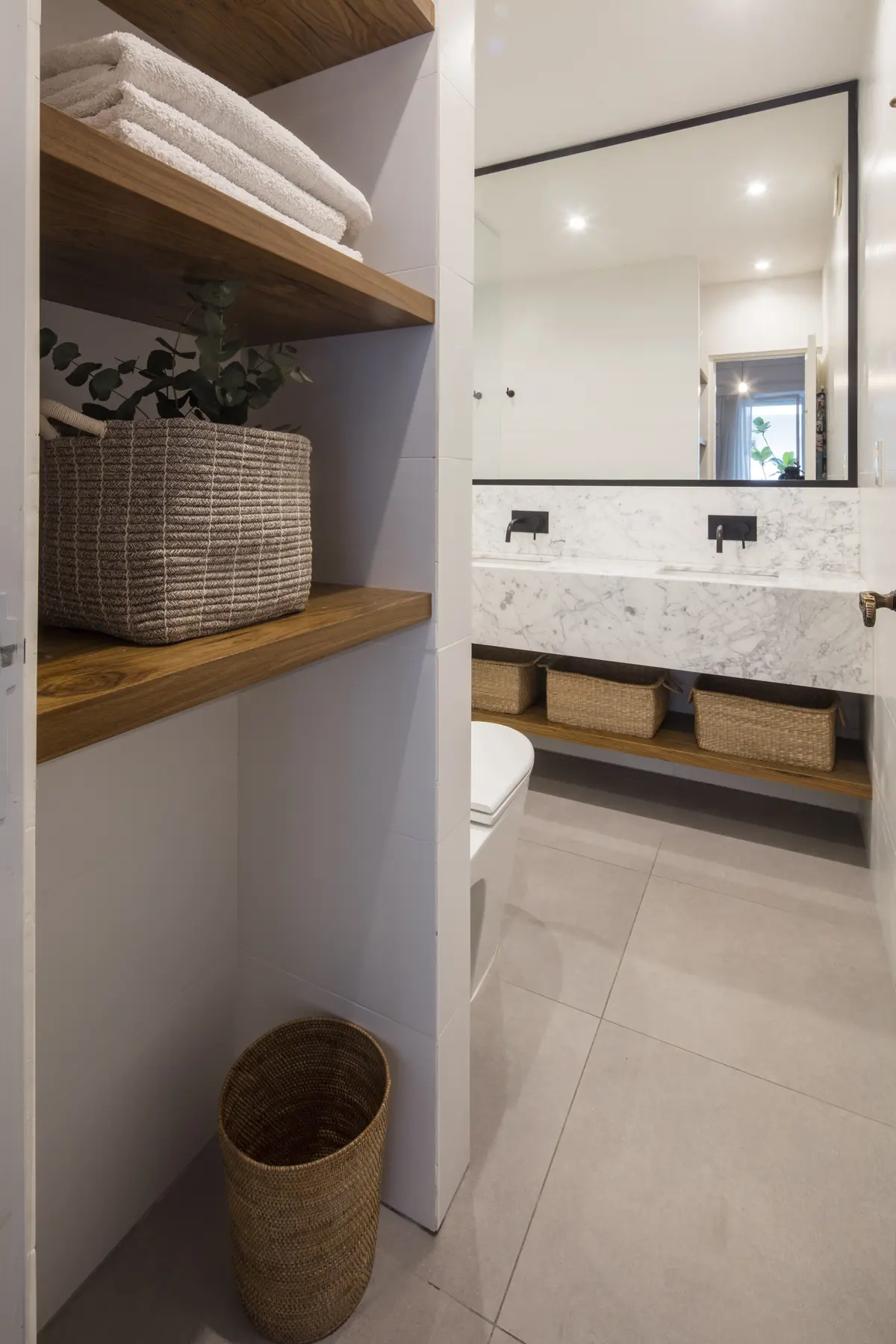 Baño moderno con estanterías de madera y doble vanitory — proyecto Juncal, por Parq Estudio, en CABA