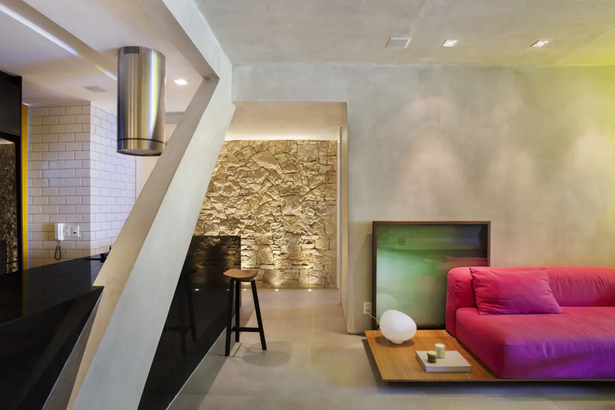 Living contemporáneo con sofá fucsia, muro texturado iluminado y doble altura — proyecto MM House, por Studio Ro-ca